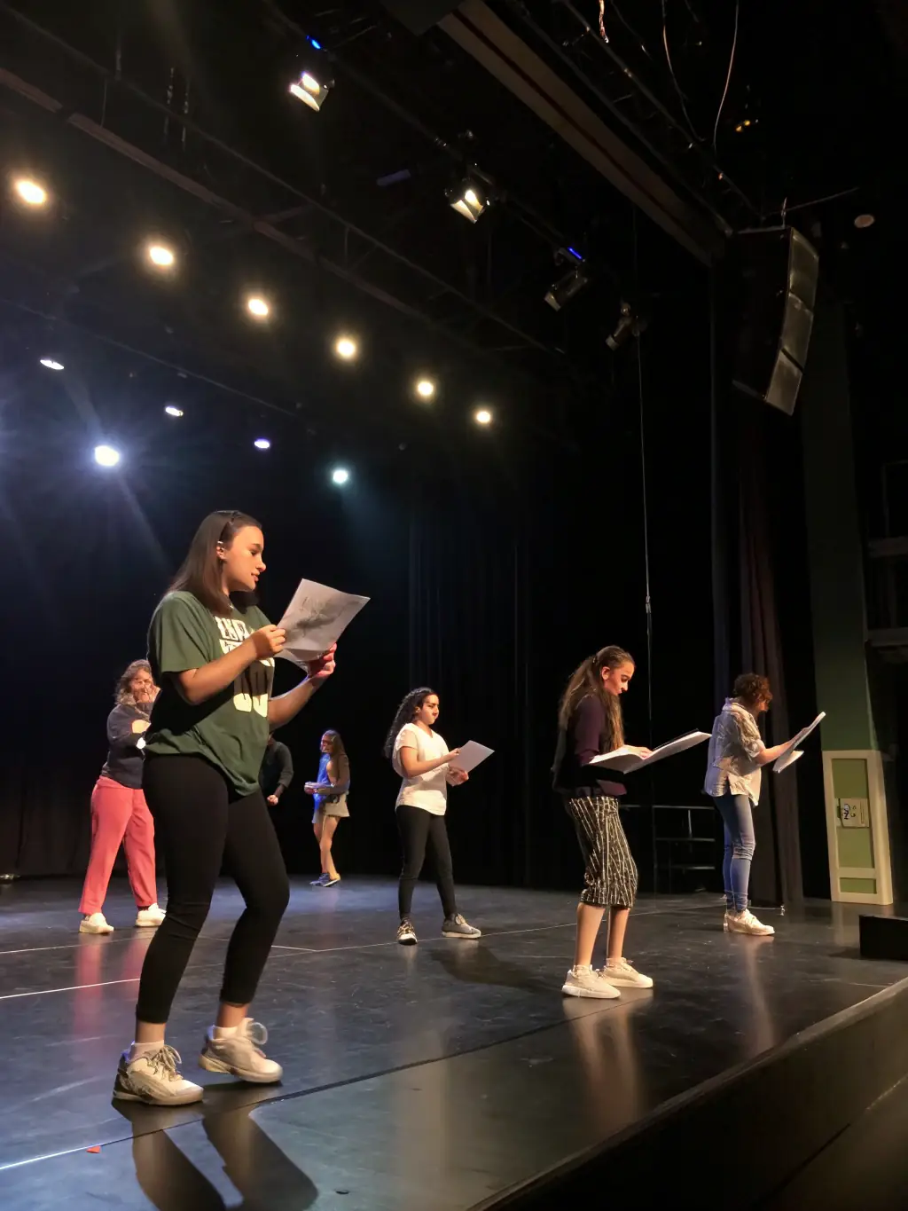 A vibrant image of participants engaging in a lively theater workshop, with actors practicing on stage under professional lighting, showcasing the dynamic and interactive nature of the workshops.